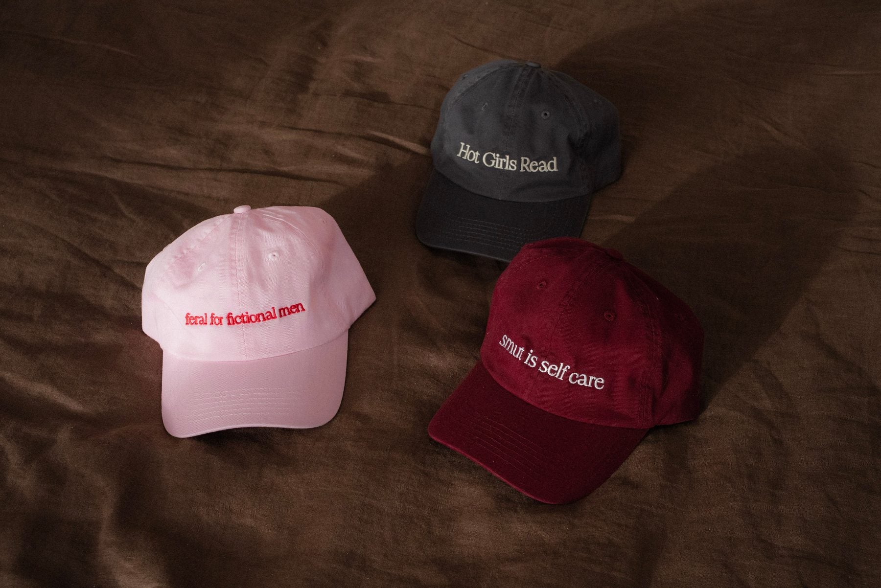 Ladies Who Lit dad cap in pink, reading Feral for fictional men
